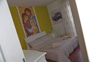 1 dormitorio con 1 cama con una pintura en la pared en Suite Gravina + box auto privato, en Gravina in Puglia