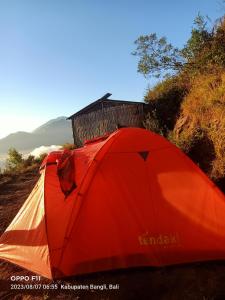 a red tent sitting on the side of a hill at Gunung Batur camp in Kintamani