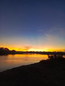 un coucher de soleil sur une étendue d'eau dans l'établissement WaitaAmazonlodge, 