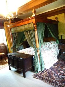 a bedroom with a canopy bed and a table at The Great Hall in Penrith