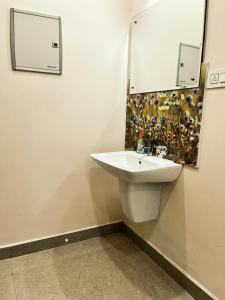 uma casa de banho com um lavatório branco e um espelho. em Thrissur Villas Home Stay em Thrissur