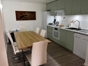 eine Küche mit grünen Schränken und einem Holztisch in der Unterkunft Trés belle suite prés mer et golf avec piscine in Saint-Côme