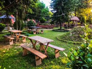 a group of picnic tables in a park at Hotel Tharu Garden And Beer Bar in Chitwan