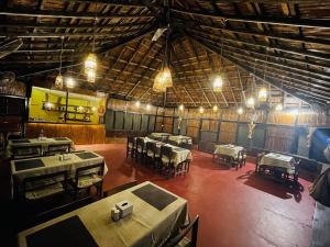 duży pokój ze stołami i krzesłami w obiekcie Hotel Tharu Garden And Beer Bar w mieście Chitwan