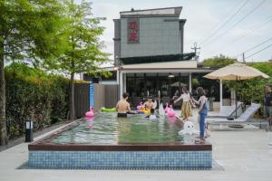 grupa ludzi w basenie z fontanną wodną w obiekcie Sakura VILLA B&B w mieście Yuanshan