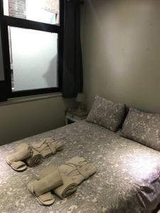 um quarto com uma cama com sandálias e uma janela em Petite maison Liégeoise «la cabane de Liège» em Liège