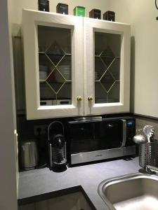 a kitchen with a sink and a microwave at Petite maison Liégeoise «la cabane de Liège» in Liège