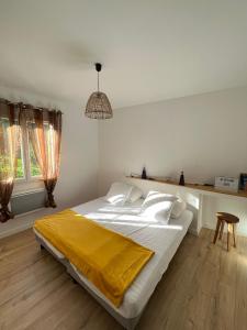 a bedroom with a large bed with a yellow blanket on it at Le bon appart' in Saint-Jean-Pied-de-Port