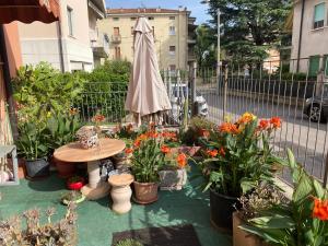 un patio con mesa, flores y sombrilla en B&B Anna Fiera, en Verona