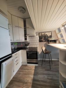 a kitchen with white cabinets and a chair in it at Studio in Kallio in Helsinki