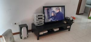 uma televisão de ecrã plano sentada num centro de entretenimento em Apartamento Santos em Ribeira Grande