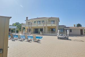 uma casa grande com cadeiras e uma piscina em Sparta Luxury Villa em Protaras