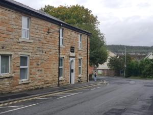a brick building on a street with a person standing next to it at Blackwood Residence in Accrington