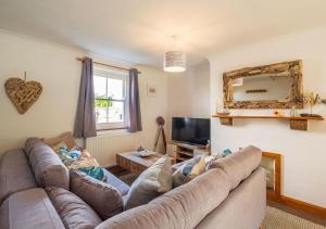 a living room with a couch and a television at Sea Shanty Cottage in Newlyn