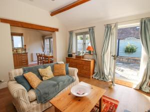 a living room with a couch and a table at Virginia Cottage in Acton Burnell