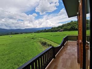 a balcony with a view of a large green field at บ้านฮิมนาปัวรีสอร์ท in Pua