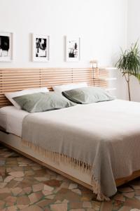 1 dormitorio con 1 cama grande y cabecero de madera en AB OvO, en Cagliari