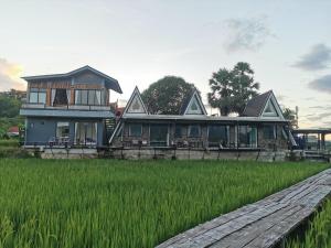 uma casa no meio de um campo de arroz em บ้านฮิมนาปัวรีสอร์ท em Pua