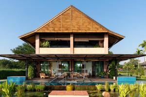 a house with a pool in front of it at Chalala villa with bio-pool & Sala! in Chiang Mai