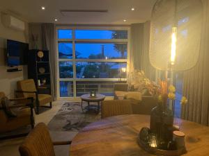 a living room with a table and a large window at Luxus Chalet Hafenblick in Lathum