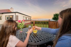 dos chicas sentadas en una mesa con bebidas en Herdsman's House en Sligo