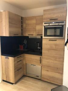 a kitchen with wooden cabinets and a stove top oven at Golf Saint Cyprien ground floor 2 bedrooms Apartment with terrace in Saint-Cyprien