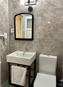 a bathroom with a sink and a toilet and a mirror at Lemon-Ada Butik Otel in Kusadası