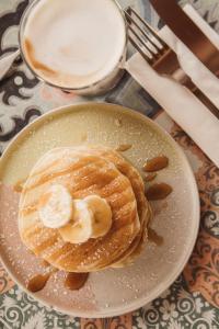 une assiette avec des crêpes à la banane et une tasse de lait dans l'établissement Monte Simeone, à Polignano a Mare