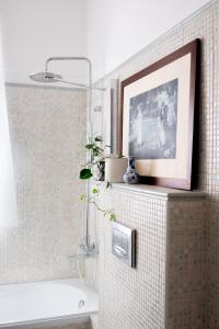 a bathroom with a picture on a tiled wall at AB OvO in Cagliari