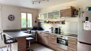eine Küche mit Holzschränken und einer Arbeitsplatte in der Unterkunft Charmante maison Proche centre-ville in Rambouillet