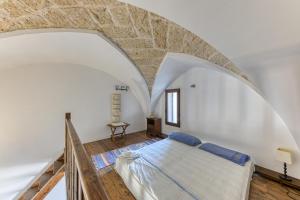 een slaapkamer met een groot bed in een stenen muur bij Antica dimora nel capo di Leuca in Alessano