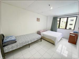 a bedroom with two beds and a window at Sea & Wave #1 Coral Bay Apartment in Pangkor
