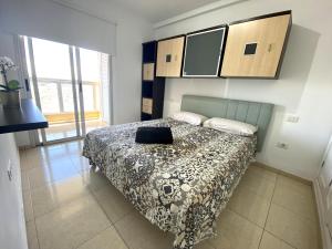 a bedroom with a bed with a black purse on it at Apartamentos Medano - La Ladera in El Médano