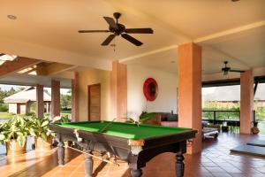 a pool table in a living room with a ceiling fan at Chalala villa with bio-pool & Sala! in Chiang Mai