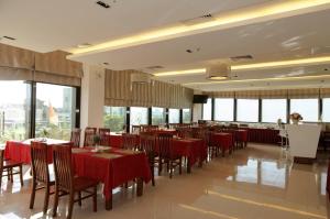 a restaurant with red tables and chairs and windows at Cam Thanh Hotel in Quảng Ngãi