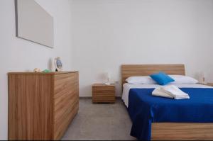 a bedroom with a bed and a wooden dresser at Casa EmiSa in Casalabate