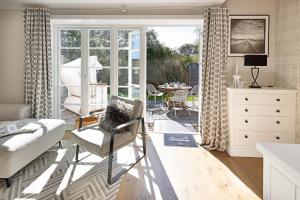 ein Wohnzimmer mit Sofa, Stühlen und einem Tisch in der Unterkunft Lister Brise in List