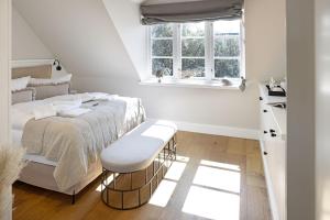 ein weißes Schlafzimmer mit einem Bett und einem Fenster in der Unterkunft Lister Brise in List