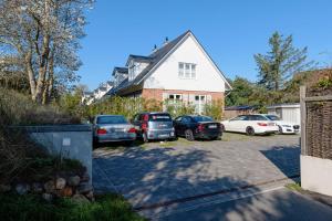 eine Gruppe von Autos, die in einer Einfahrt geparkt sind in der Unterkunft Lister Brise in List