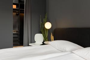 Un dormitorio con una cama blanca y una planta en Elegant Apartment Kasprzaka in Wola by Renters Prestige en Varsovia