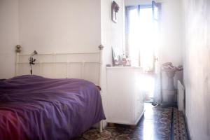 a bedroom with a bed with a purple blanket and a window at Chez Fred & Aldo Banyuls sur Mer in Banyuls-sur-Mer
