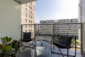 - Balcón con sillas y mesa en el balcón en Elegant Apartment Kasprzaka in Wola by Renters Prestige en Varsovia