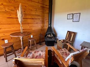a living room with a stove and a table and chairs at Pousada Rural Vista Alegre in Bom Jardim da Serra
