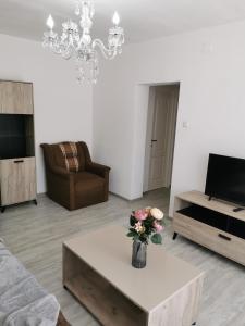 a living room with a vase of flowers on a coffee table at Apartament Alba Iulia in Alba Iulia