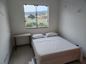 a small bedroom with a bed and a window at Comfort 302 - 4 Quartos no Centro in Sete Lagoas