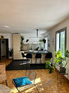 a living room with a table and chairs and a kitchen at Superbe appartement au porte de Paris et du salon des expositions in Vanves