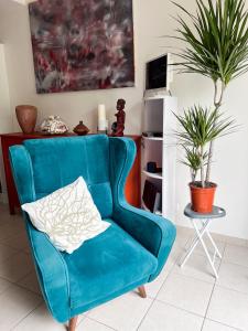 einen blauen Stuhl mit Kissen im Wohnzimmer in der Unterkunft Charmante maison Proche centre-ville in Rambouillet