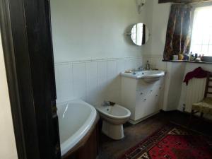 ein Badezimmer mit einer Badewanne, einem WC und einem Waschbecken in der Unterkunft The Great Hall in Penrith