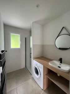 a bathroom with a washing machine and a sink at Le bon appart' in Saint-Jean-Pied-de-Port