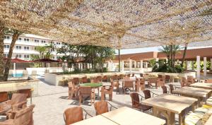 a restaurant with tables and chairs under a canopy at tent Calvia Beach in Magaluf